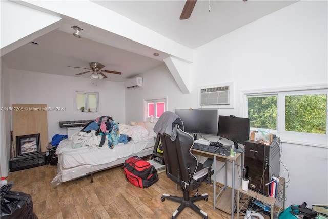 bedroom with wood-type flooring, a wall unit AC, and ceiling fan