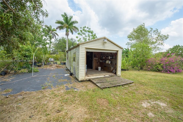 view of outdoor structure with a lawn and a garage