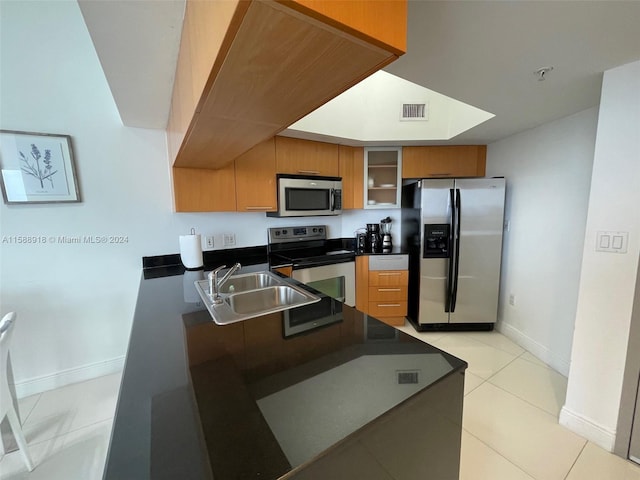 kitchen featuring sink, light tile floors, and stainless steel appliances