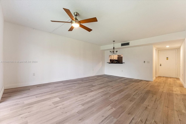 unfurnished living room with light wood-type flooring and ceiling fan with notable chandelier