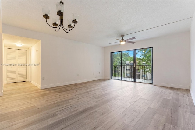 empty room with light hardwood / wood-style floors, a textured ceiling, and ceiling fan with notable chandelier