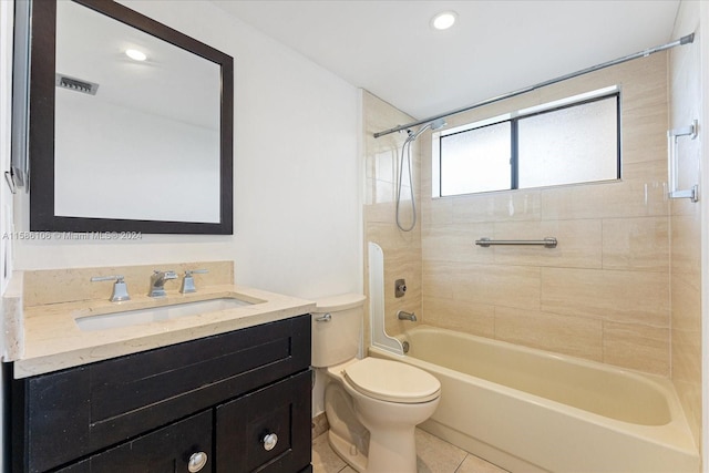 full bathroom featuring tile flooring, tiled shower / bath, vanity, and toilet