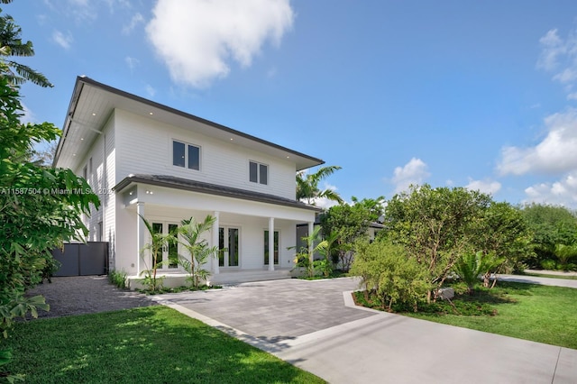 contemporary home featuring covered porch and a front lawn