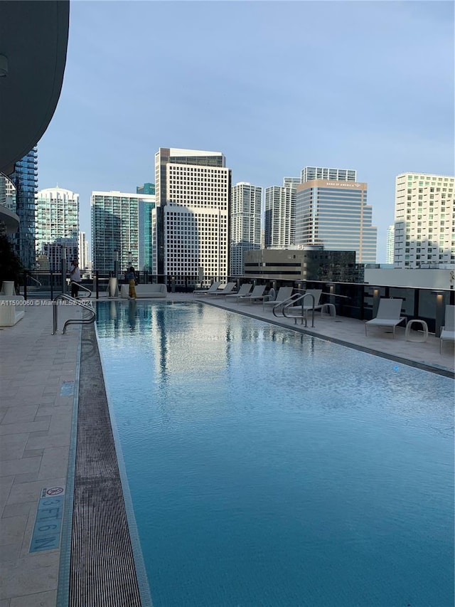 view of swimming pool with a water view and a patio