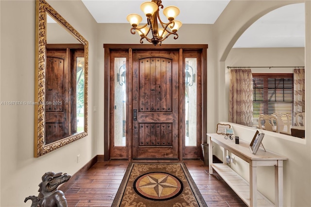 entrance foyer with dark wood-type flooring, a chandelier, and a healthy amount of sunlight