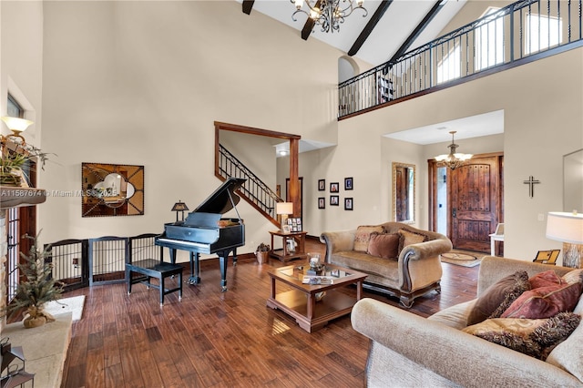 living room featuring dark wood-type flooring, beam ceiling, high vaulted ceiling, and a notable chandelier