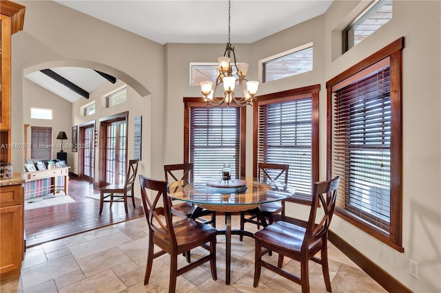 dining space featuring vaulted ceiling with beams and an inviting chandelier