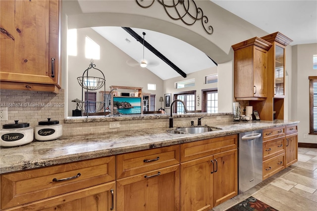 kitchen featuring vaulted ceiling, ceiling fan, sink, tasteful backsplash, and light stone countertops