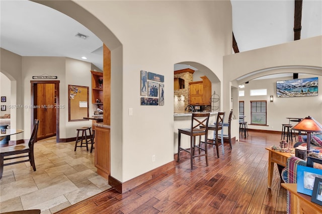 hallway featuring a towering ceiling and light hardwood / wood-style floors