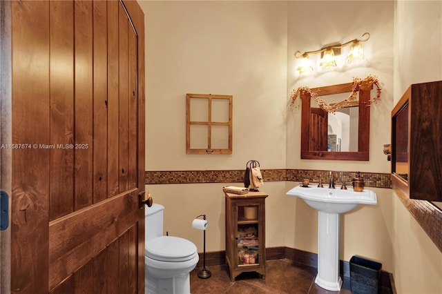 bathroom featuring toilet and tile patterned flooring