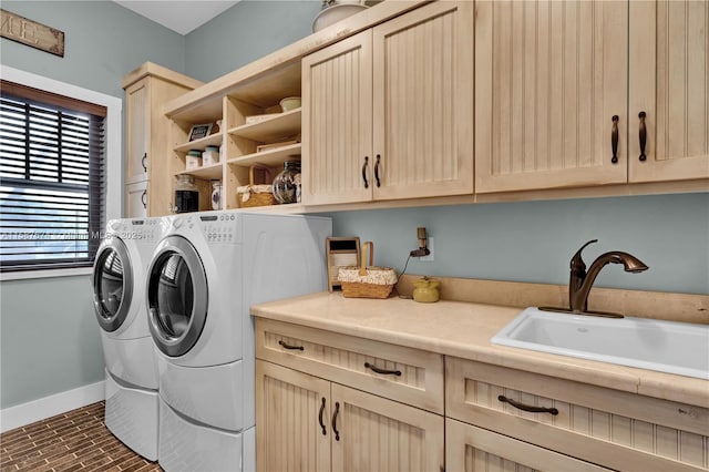 laundry area with sink, cabinets, and separate washer and dryer