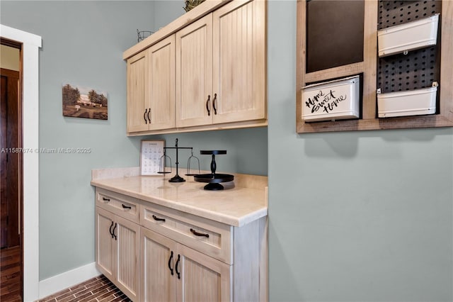 bar featuring light brown cabinetry