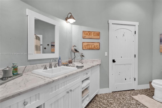 bathroom with toilet, vanity, and tile patterned flooring