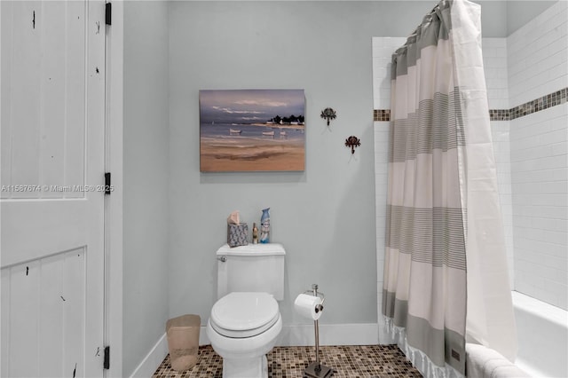 bathroom with shower / bath combo with shower curtain, toilet, and tile patterned flooring