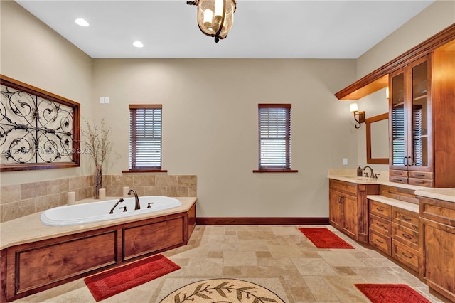 bathroom featuring plenty of natural light, vanity, and a bathtub