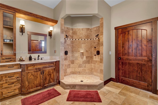 bathroom featuring tiled shower and vanity