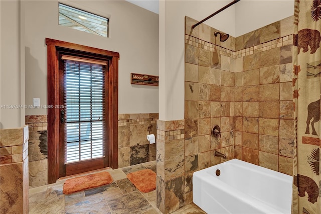 bathroom with shower / bath combo with shower curtain and tile walls