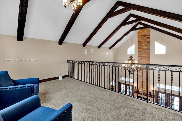 living area featuring a chandelier, beamed ceiling, and carpet