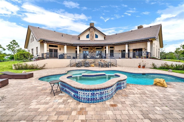 view of swimming pool featuring an in ground hot tub and a patio area