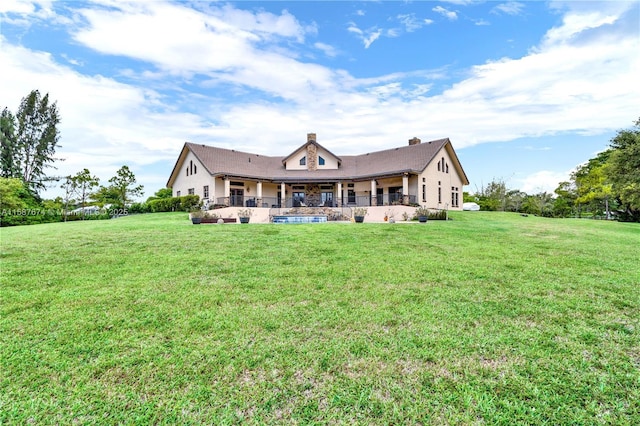 back of house featuring a lawn and a patio