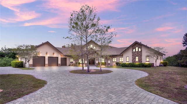 view of front of house with a garage and a yard