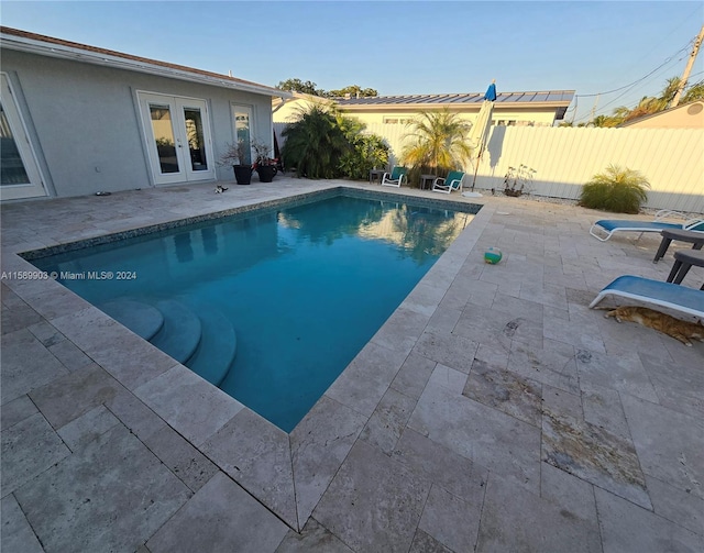 view of swimming pool with french doors and a patio