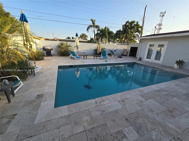 view of swimming pool with a patio, grilling area, and french doors