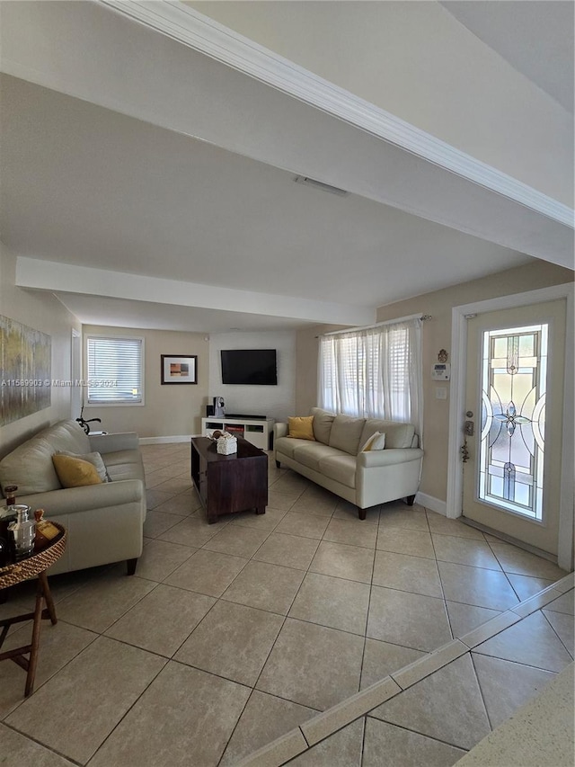 living room featuring ornamental molding and light tile floors