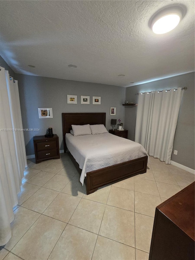 bedroom featuring a textured ceiling and light tile floors