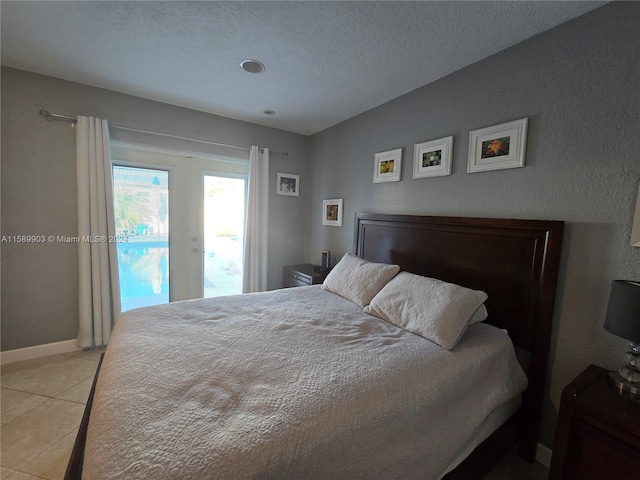 tiled bedroom featuring a textured ceiling and access to outside