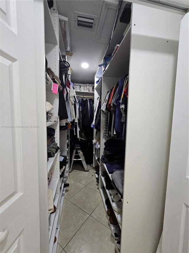 spacious closet with light tile floors