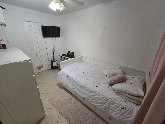 tiled bedroom with a closet and ceiling fan