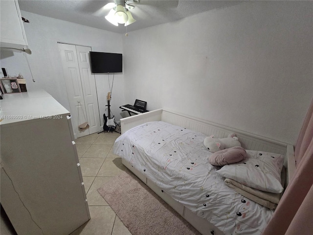 bedroom with a closet, ceiling fan, and light tile floors