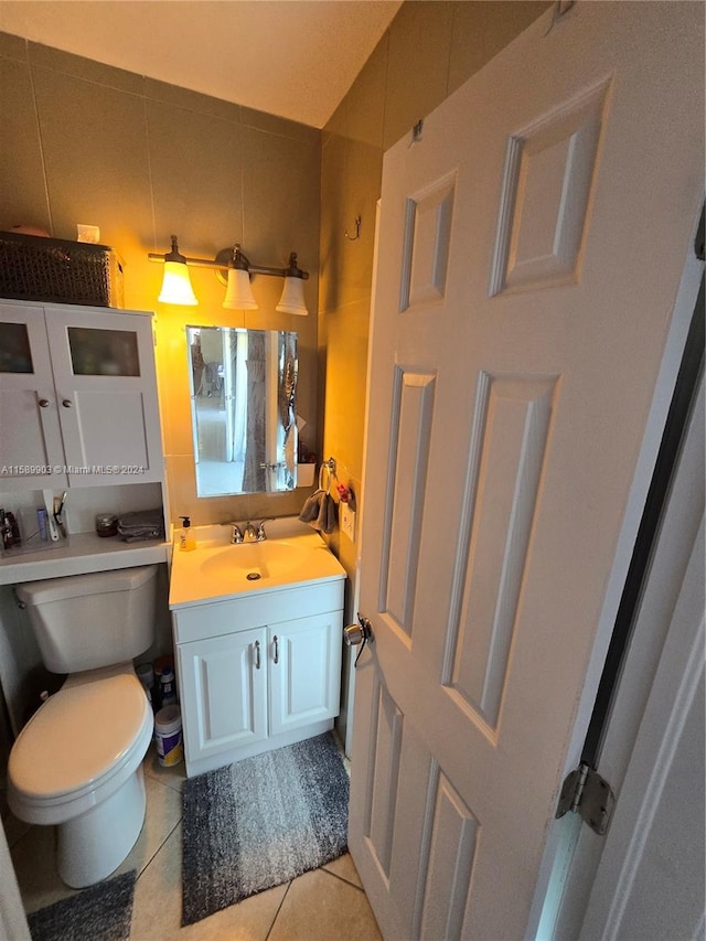 bathroom with tile flooring, vanity, toilet, and tasteful backsplash