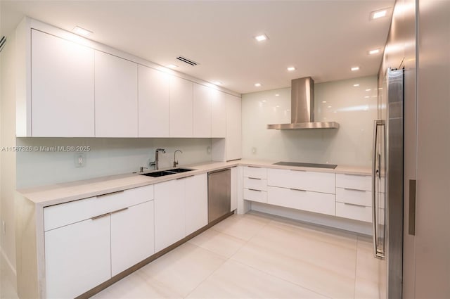 kitchen with white cabinets, light countertops, stainless steel dishwasher, wall chimney exhaust hood, and modern cabinets