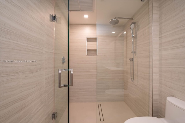 bathroom featuring a stall shower and toilet