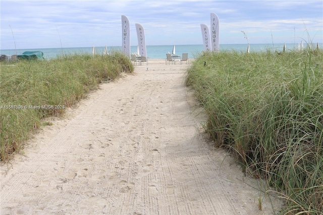 surrounding community with a beach view and a water view