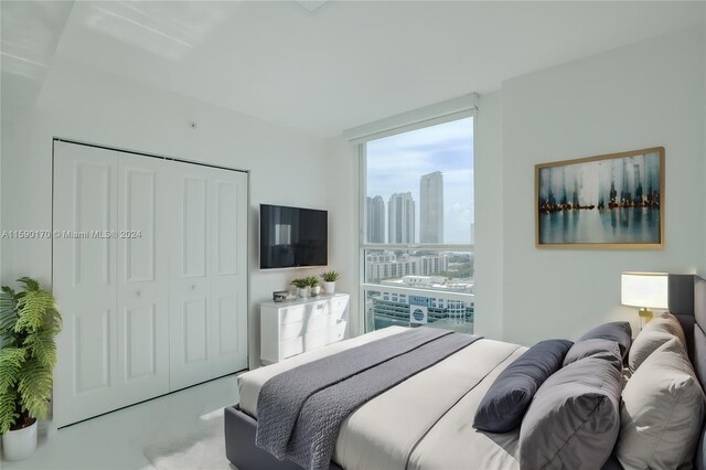 carpeted bedroom featuring floor to ceiling windows and a closet