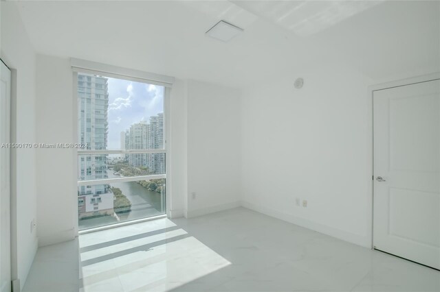 spare room featuring tile patterned flooring and floor to ceiling windows