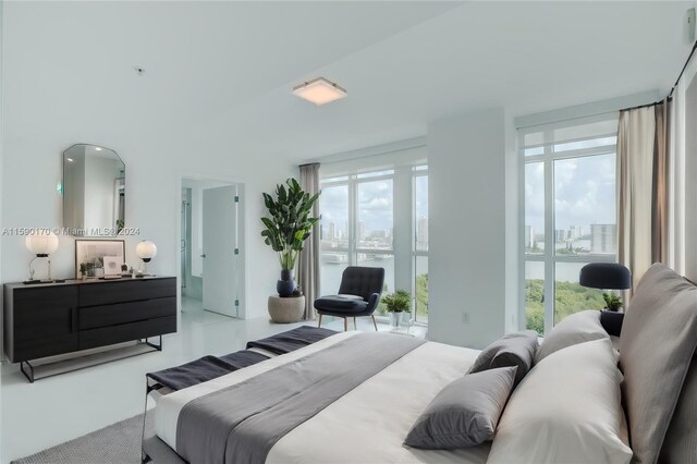 spare room with tile patterned flooring, a water view, and floor to ceiling windows