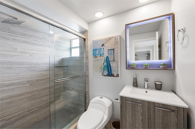 bathroom with a shower with door, toilet, and vanity