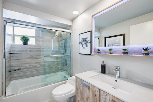 full bathroom with vanity, toilet, and bath / shower combo with glass door