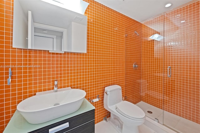 bathroom featuring a shower with shower door, tile walls, toilet, and vanity