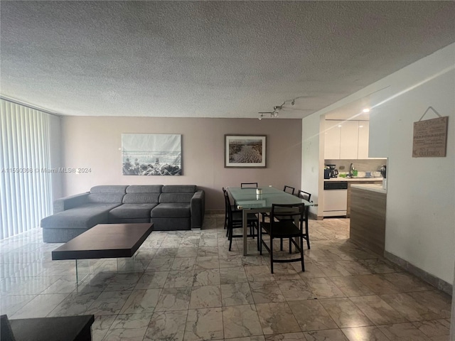 living room featuring a textured ceiling and rail lighting