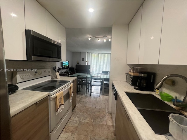 kitchen with white cabinetry, white electric range, tasteful backsplash, and sink