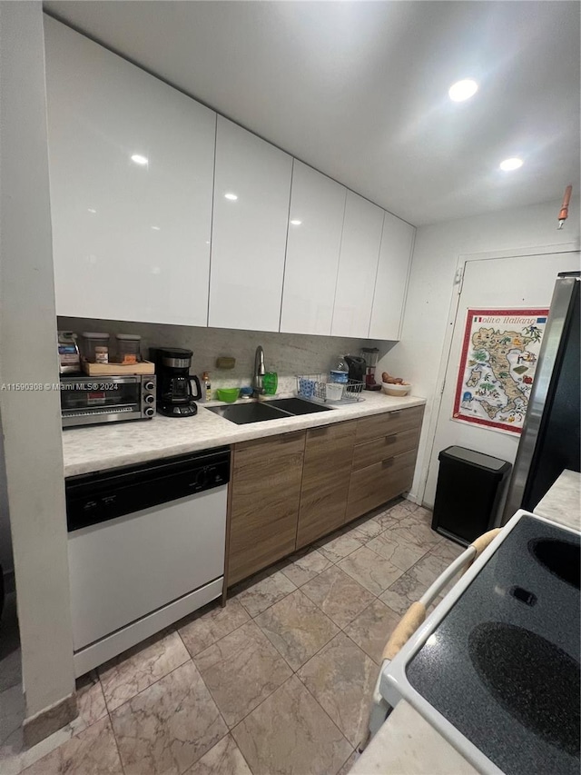 kitchen featuring white cabinetry, sink, and white appliances