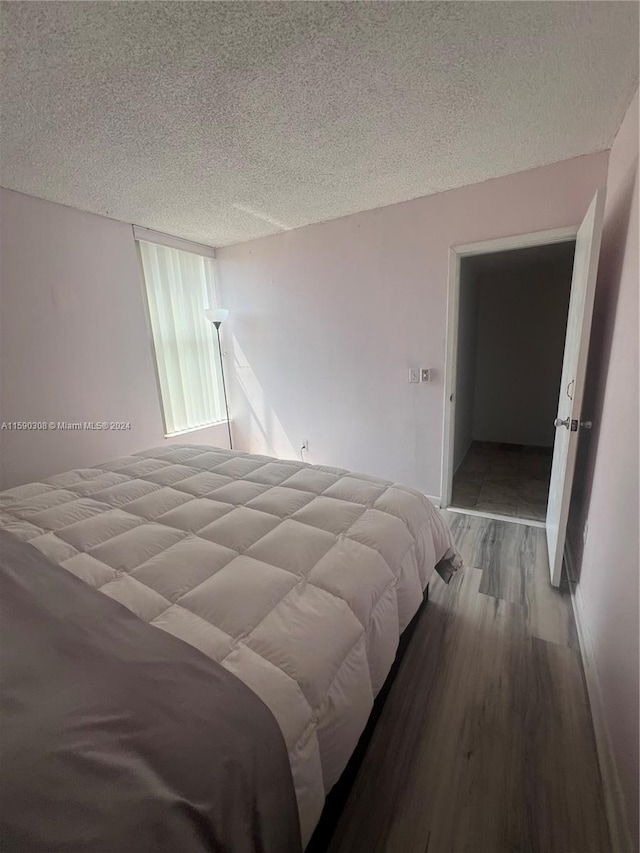 bedroom featuring a textured ceiling and hardwood / wood-style floors