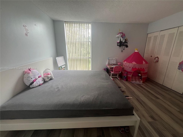 bedroom featuring a textured ceiling, dark hardwood / wood-style floors, and a closet