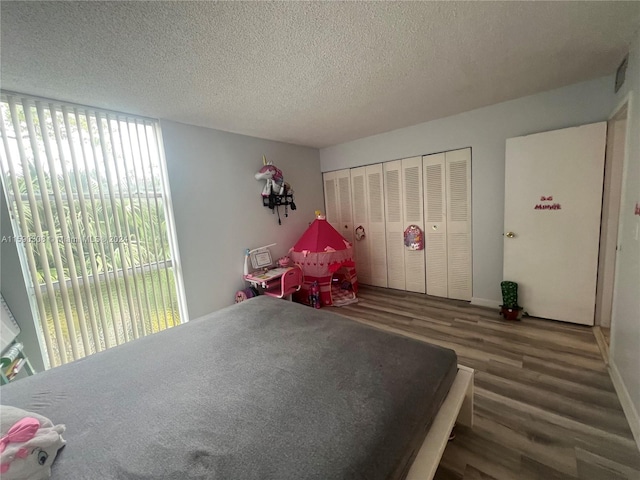 bedroom featuring a closet, a textured ceiling, and dark wood-type flooring