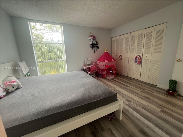 bedroom featuring a textured ceiling, wood-type flooring, and a closet